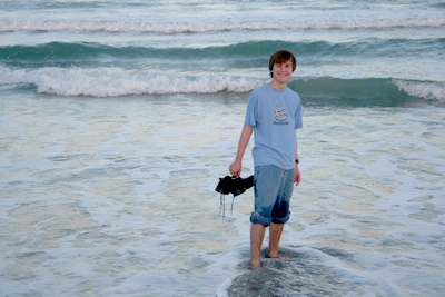 Joey with rolled up jeans walking in surf